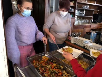 Zwei Personen geben Essen aus.